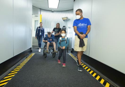Two families walk down the jet bridge